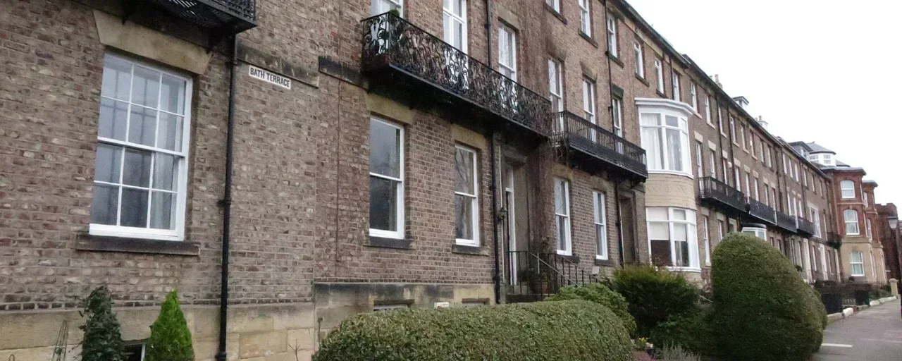 Brick terraced houses with iron balconies on Bath Terrace, Tynemouth