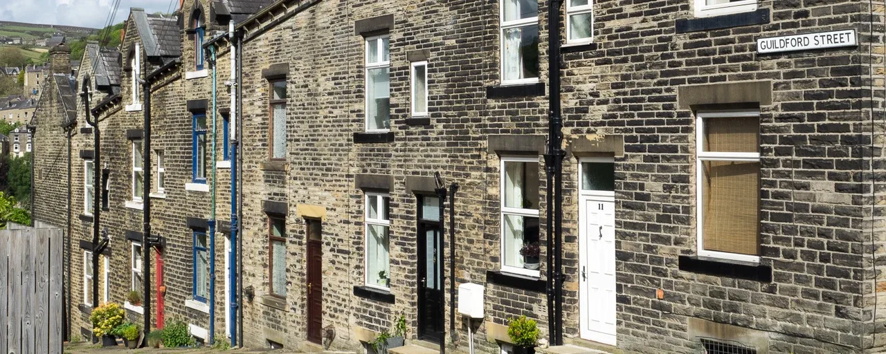 Stone terraced houses lining steep Guildford Street in Hebden Bridge